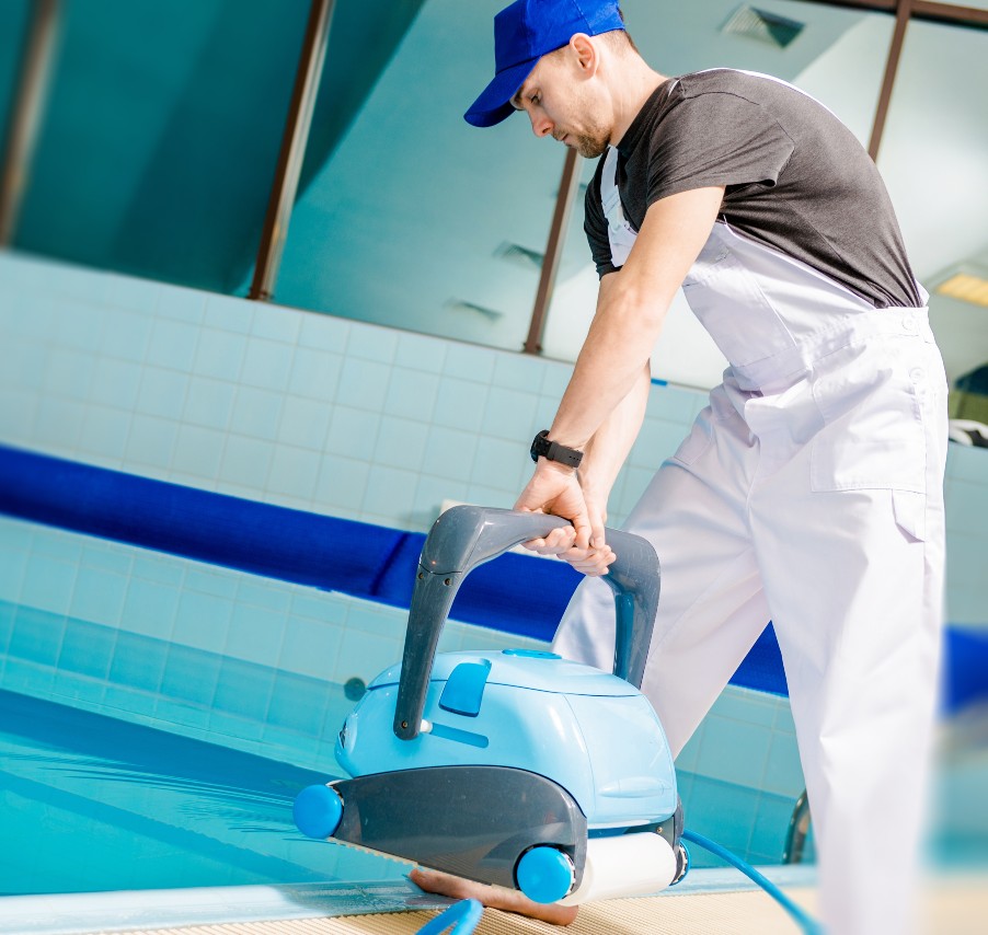 Pool technician guiding an automatic pool cleaner into the water